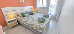 a small bedroom with a bed with a bedspread and pillows at Le Panorama des Pyrénées in Tarbes