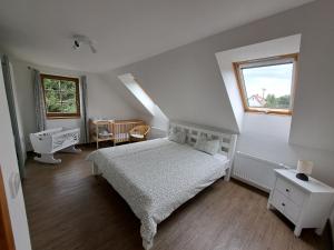 a white bedroom with a bed and a window at Loučná in Hrádek nad Nisou