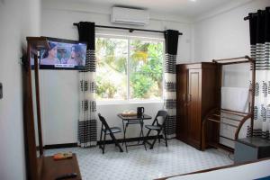 PamunugamaにあるMario Ocean Viewのテーブルと椅子と窓のあるリビングルーム