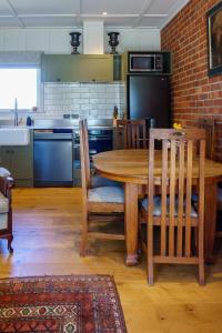 a kitchen with a wooden table and chairs and a kitchen with a counter at Historic Castle Coach House in Earnscleugh