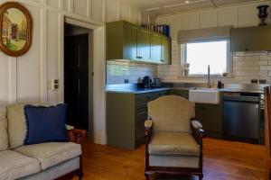 a kitchen with a couch and chairs in a room at Historic Castle Coach House in Earnscleugh