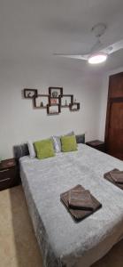 una camera da letto con un letto grande con cuscini verdi di Apartamento Tres Playas a Puerto de Mazarrón