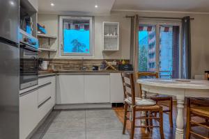 a kitchen with white cabinets and a table at #ER Les Alliés The Bright and cosy T4 with view in Grenoble
