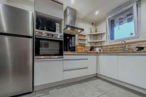 a kitchen with white cabinets and a stainless steel refrigerator at #ER Les Alliés The Bright and cosy T4 with view in Grenoble +21 photos