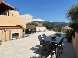 eine Terrasse mit Tisch und Stühlen und einem Pool in der Unterkunft Campanet Soul Village Home with Pool & Sea Views in Campanet