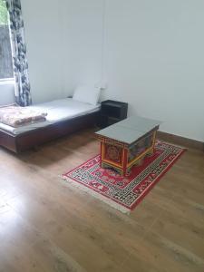 a living room with a coffee table on a rug at Nyidon Residency in Dirang Dzong