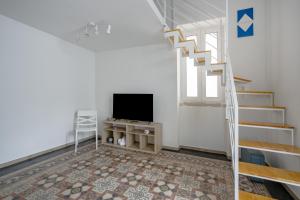 a living room with a staircase and a television at Gabbiano 2 - Sea Loft in Bari
