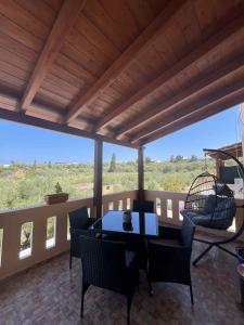 een terras met een tafel en stoelen op een balkon bij Angellinas Apartments in Kato Daratso