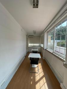 an empty room with a table and two windows at Residencial Sky Lounge in Lisbon