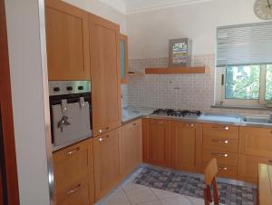 a kitchen with wooden cabinets and a stove top oven at La Bombon era in Scalea