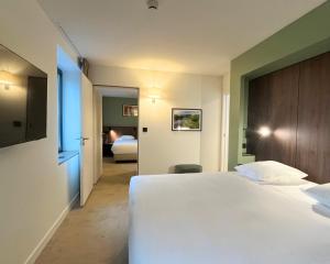 a hotel room with a large white bed and a bedroom at Hob La Truffière in Gignac