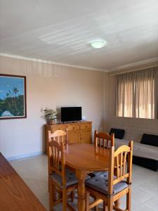 Una sala de estar con una mesa y sillas de madera. en Apartamentos Guahedun, en Valle Gran Rey