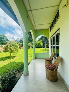 a porch of a house with two chairs on it at New Kaziranga Cottage in Kāziranga