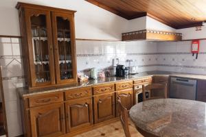 a kitchen with wooden cabinets and a table at Casa Oliveira in Fátima