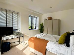 a bedroom with a bed and a desk and a television at Sophisticated 2 Bedroom apartment in Solihull NEC in Olton