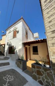 a small white house with a building at Apartment in Marathokampos Samos in Samos