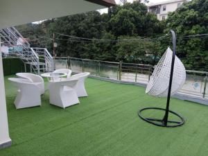 a group of white chairs and an umbrella on a roof at Nature's Key Home in Dehradun