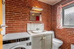 a brick bathroom with a sink and a washing machine at SJ300-Haderslev-Vikaerparken-87 in Diernæs