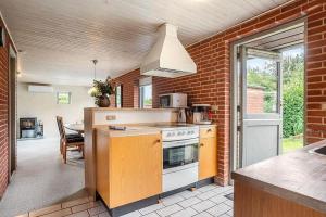 a kitchen with a white stove top oven next to a brick wall at SJ300-Haderslev-Vikaerparken-87 in Diernæs +19 photos