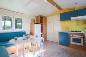 a small kitchen with a table and chairs in a room at Mobil Home entre terre et mer 