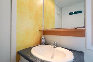 a bathroom with a sink and a mirror at Mobil Home entre terre et mer 