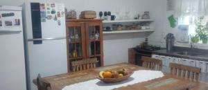 a kitchen with a table with a bowl of fruit on it at Lindo quarto casal no centro Floripa in Florianópolis