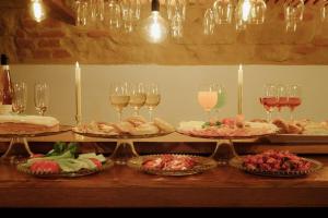 a table with several plates of food and glasses of wine at Enjoy Inn in Pilsen