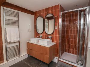 a bathroom with two sinks and a shower and mirrors at Hedgerose in Goodleigh +44 photos
