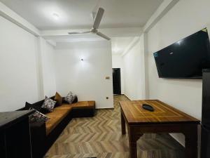 a living room with a couch and a flat screen tv at Villa Green View in Hikkaduwa