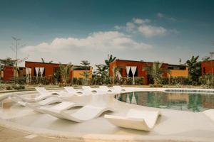ein Pool mit weißen Stühlen vor einem Gebäude in der Unterkunft Como Laya Resort in Alaminos