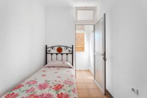Habitación pequeña con cama y puerta en Casa Amanecer Atlántico 2 Izquierda, en Playa de San Juan