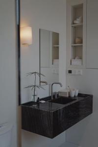 a bathroom counter with a sink and a mirror at Persimmon Restaurant Yangzhou Dongguan Street Branch in Yangzhou