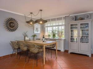 Un comedor con mesa y sillas de madera. en Beach Bungalow Sylt 2, en Dikjendeel