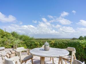 Una mesa y sillas en un patio con vista. en Beach Bungalow Sylt 2, en Dikjendeel