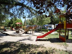 a playground with a slide in a park at Estivo mobile homes on Camping Bella Italia in Peschiera del Garda