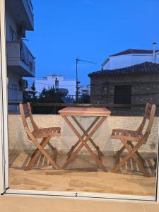 Preveza Lux & Comfort Suites في بريفيزا: طاولة نزهة وكرسيين على شرفة