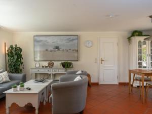 una sala de estar con un sofá y una mesa en Beach Bungalow Sylt 1, en Dikjendeel 14 fotos más