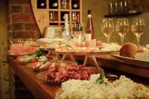 a table with plates of food and glasses of wine at Enjoy Inn in Plzeň