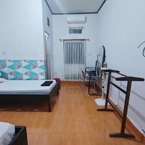 a room with a bed and a desk in it at Labore Homestay in Waha