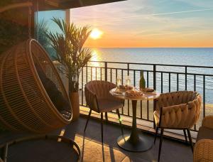 a balcony with a table and chairs and the ocean at Sea View Smart & Garden VIP Apartment in Międzyzdroje