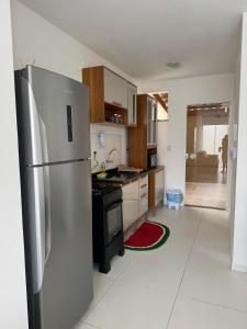 a kitchen with a stainless steel refrigerator and a stove at Casa Arruda Climatizada 4 prox Shop Boulevard in Vitória da Conquista