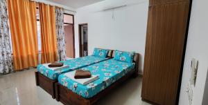 a bedroom with a bed with blue sheets at Rustic Homestay Sonipat in Sonīpat