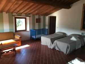 a bedroom with two beds and a couch and a chair at Tuscan Farm Home Retreat in Chianni