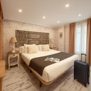 een hotelkamer met een groot bed en een koffer bij Apartamentos Sevilla Palace in Sevilla