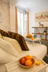 een woonkamer met een bank met sinaasappels op een tafel bij Apartamentos Sevilla Palace in Sevilla