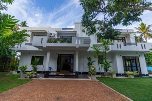 a large white house with a yard at Heaven Breeze Hotel Ahangama in Ahangama