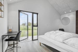 Un dormitorio con una cama y un escritorio y una ventana. en LN1947-Hjorring-Bakkestjernevej-23, en Hjørring