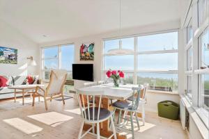 un soggiorno con tavolo, sedie e finestre di SJ271-Hejls-Ved-Kysten-2 a Hejls