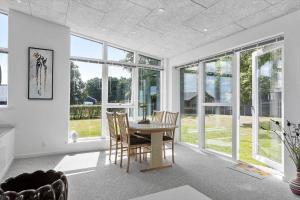 a dining room with a table and chairs and windows at SJ236-Haderslev-Blokhusskoven-53 in Haderslev
