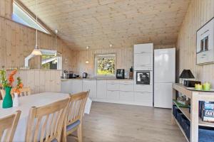 una cucina con un tavolo e un frigorifero bianco di LN1863-Hjorring-Ostersovej-2 a Hjørring